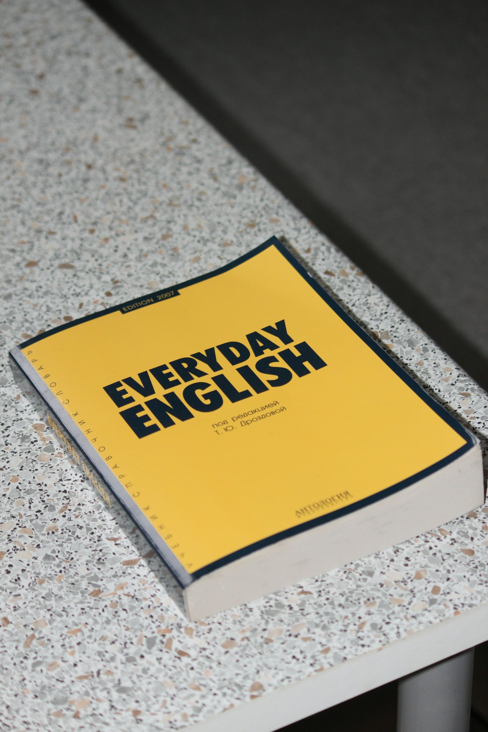 黄色封面的 Everyday English 英语学习书籍放在桌面上